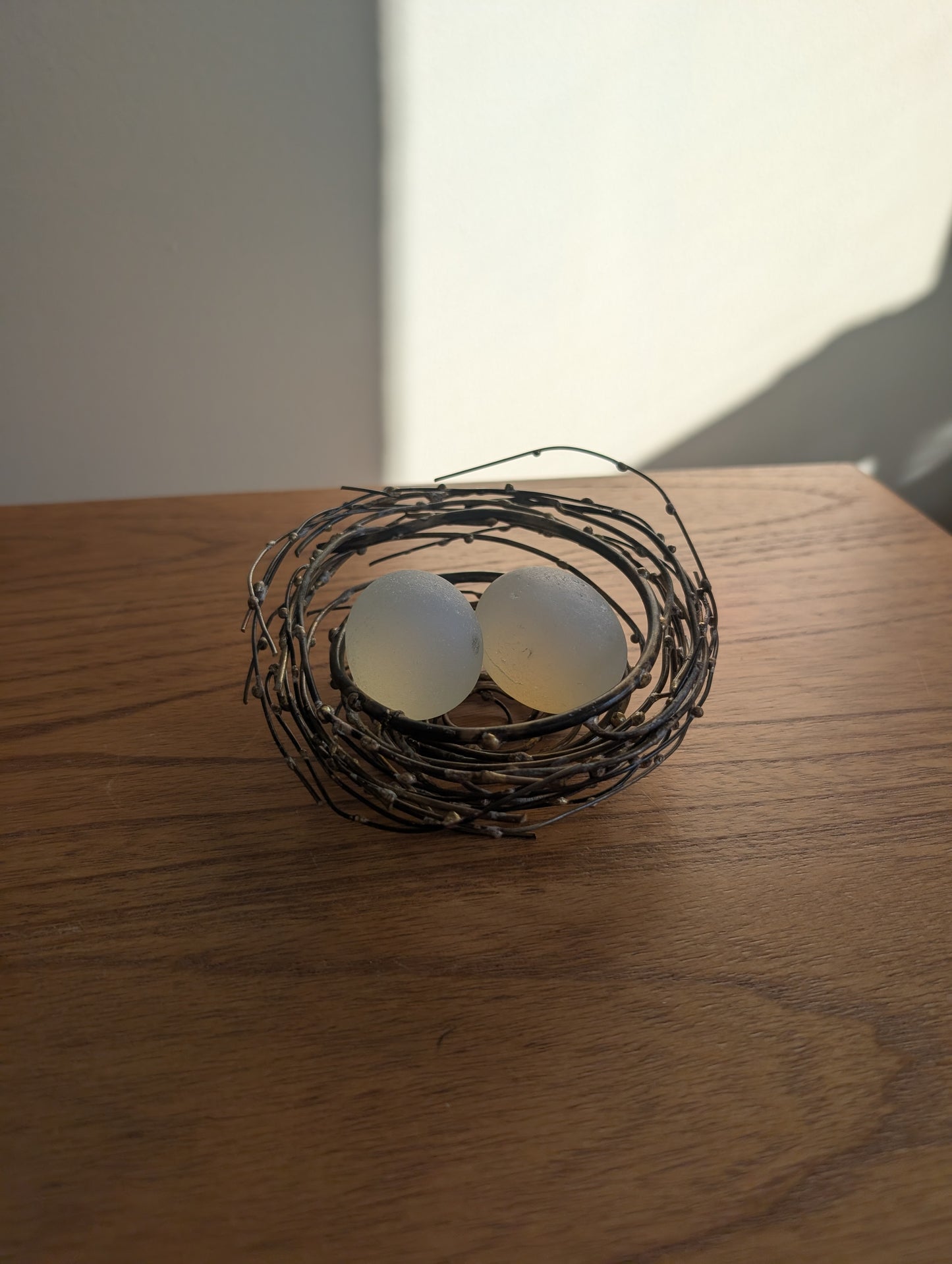 Glass or Stone Eggs in a Metal Nest